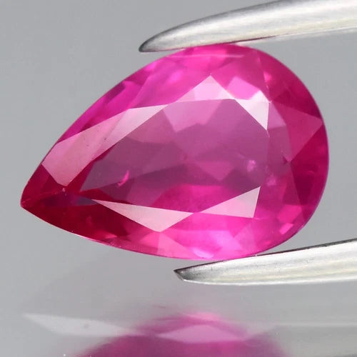 CERTIFICATE incl. 0.78ct pear-shaped pink sapphire gemstone with faceted edges, Mozambique origin, on display stand.