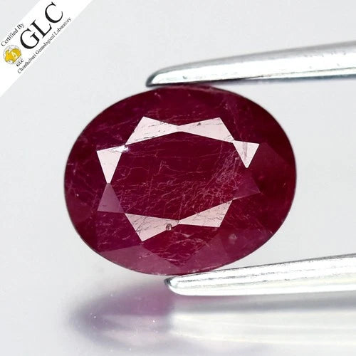 1.23ct oval ruby with deep red center, purplish red inclusions, and diamond-shaped certificate by GLC.