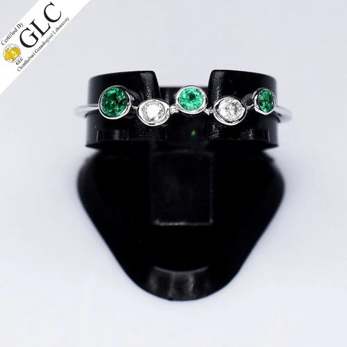 18K white gold ring with green center gemstone, diamond side stones, and “GLC” certificate on black display.